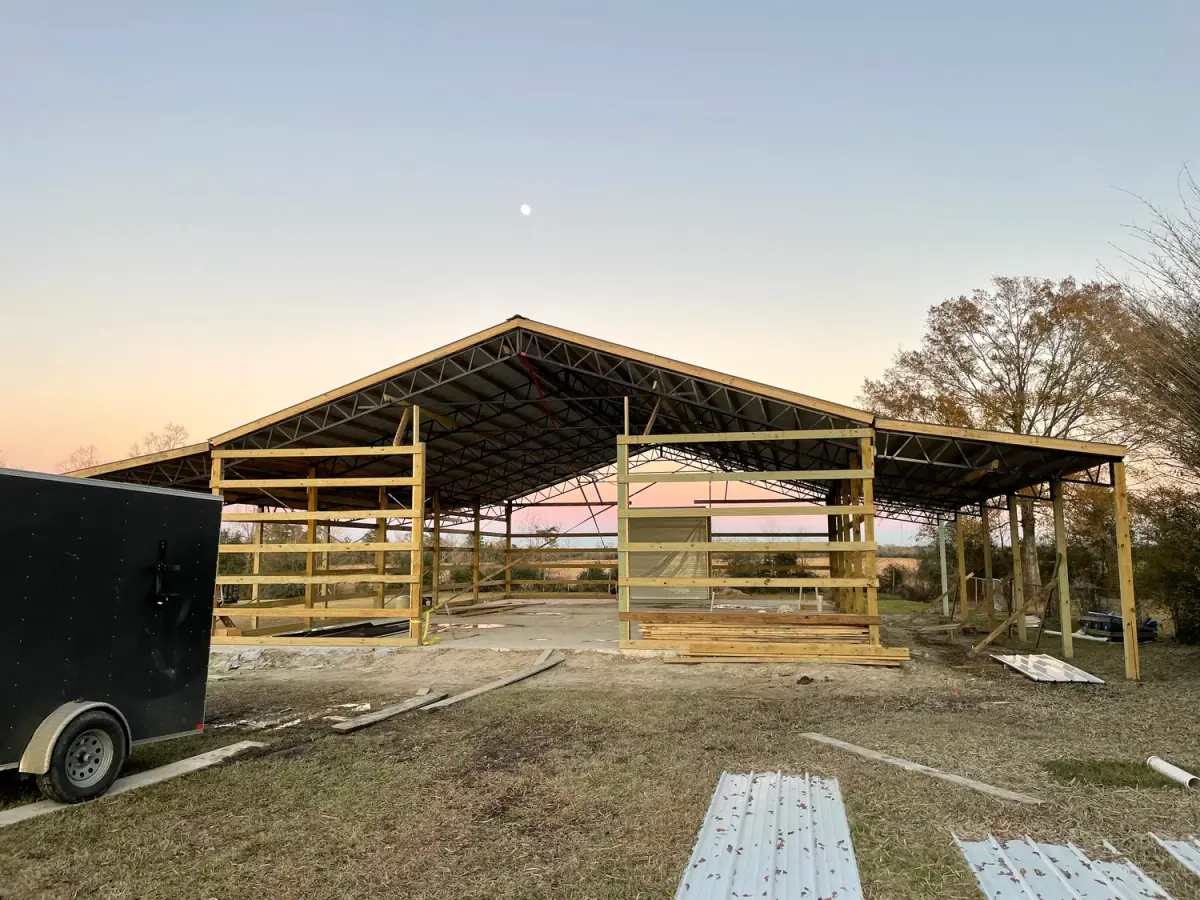 Pole barn frame going up at sunset