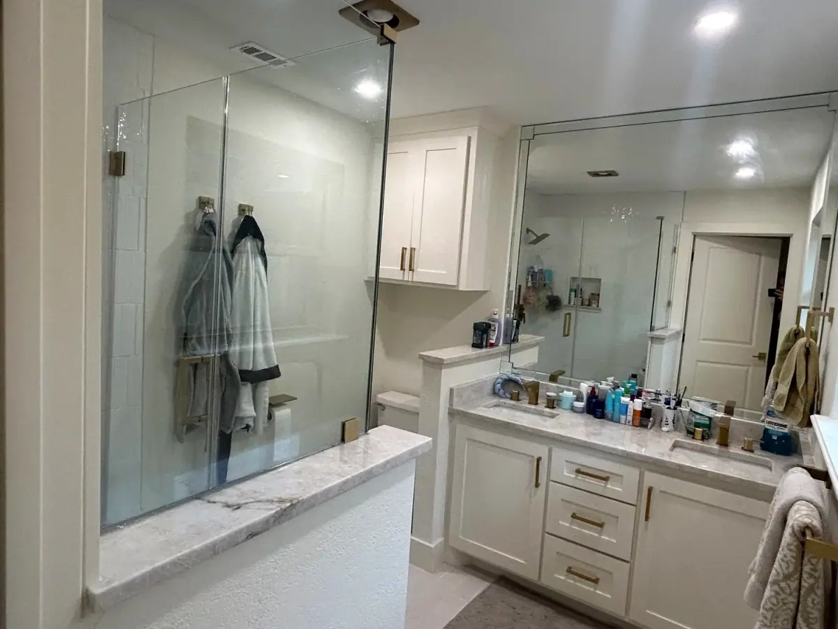 Bathroom remodel with a frameless glass shower and white vanity