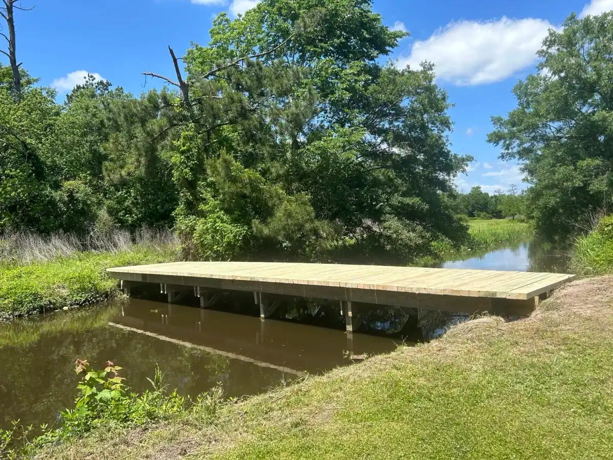 Timber bridge over a small creek between fields