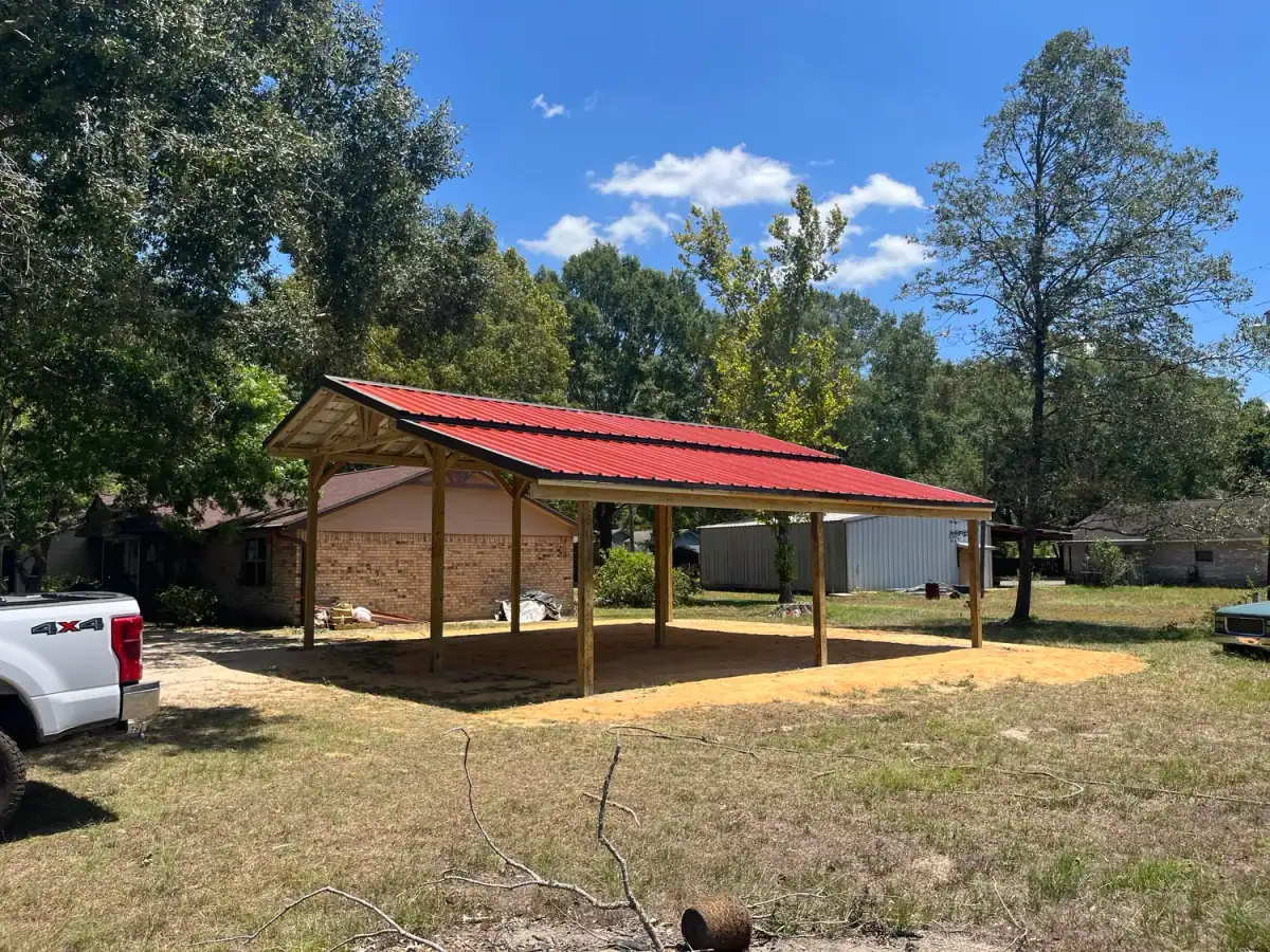 Timber carport with a red metal roof beside a house
