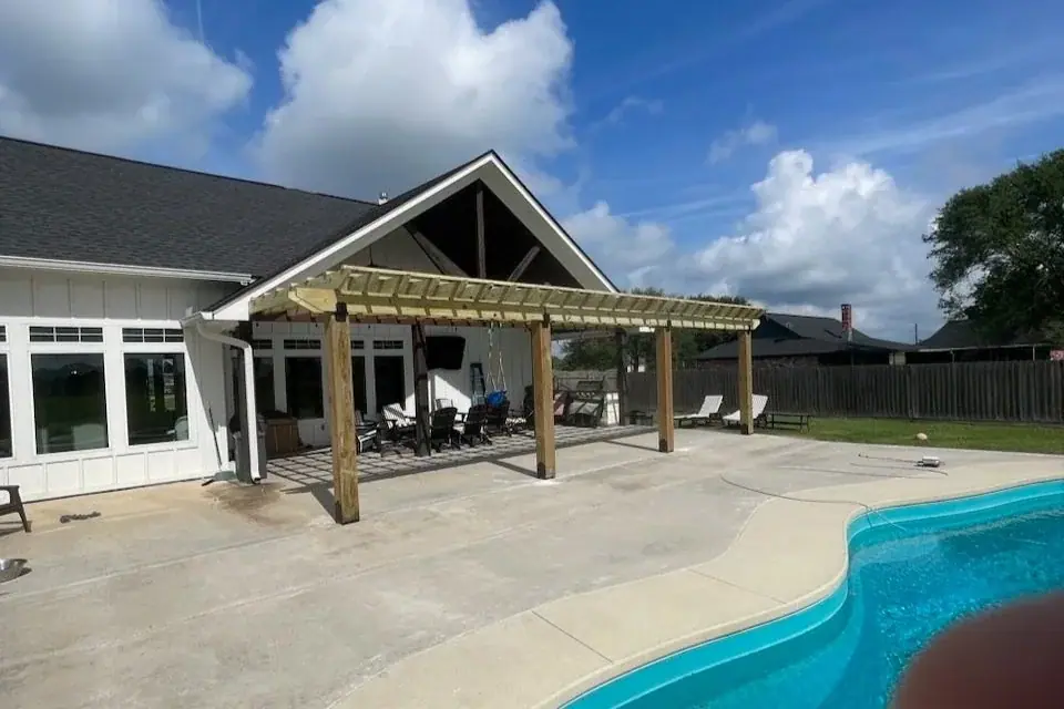 Timber patio cover attached to a house beside a pool