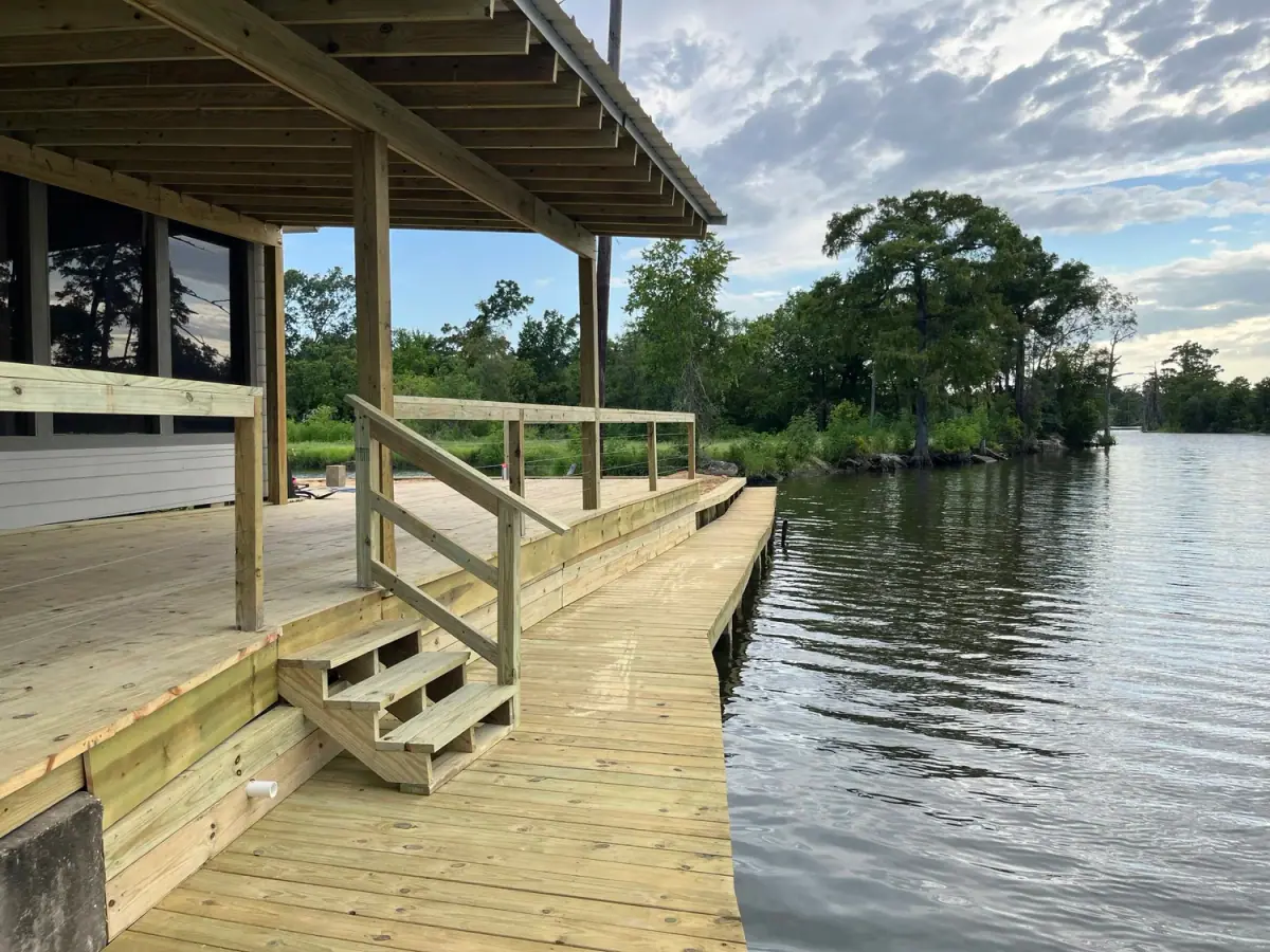 Dock walkway with a handrail beside a house on the water