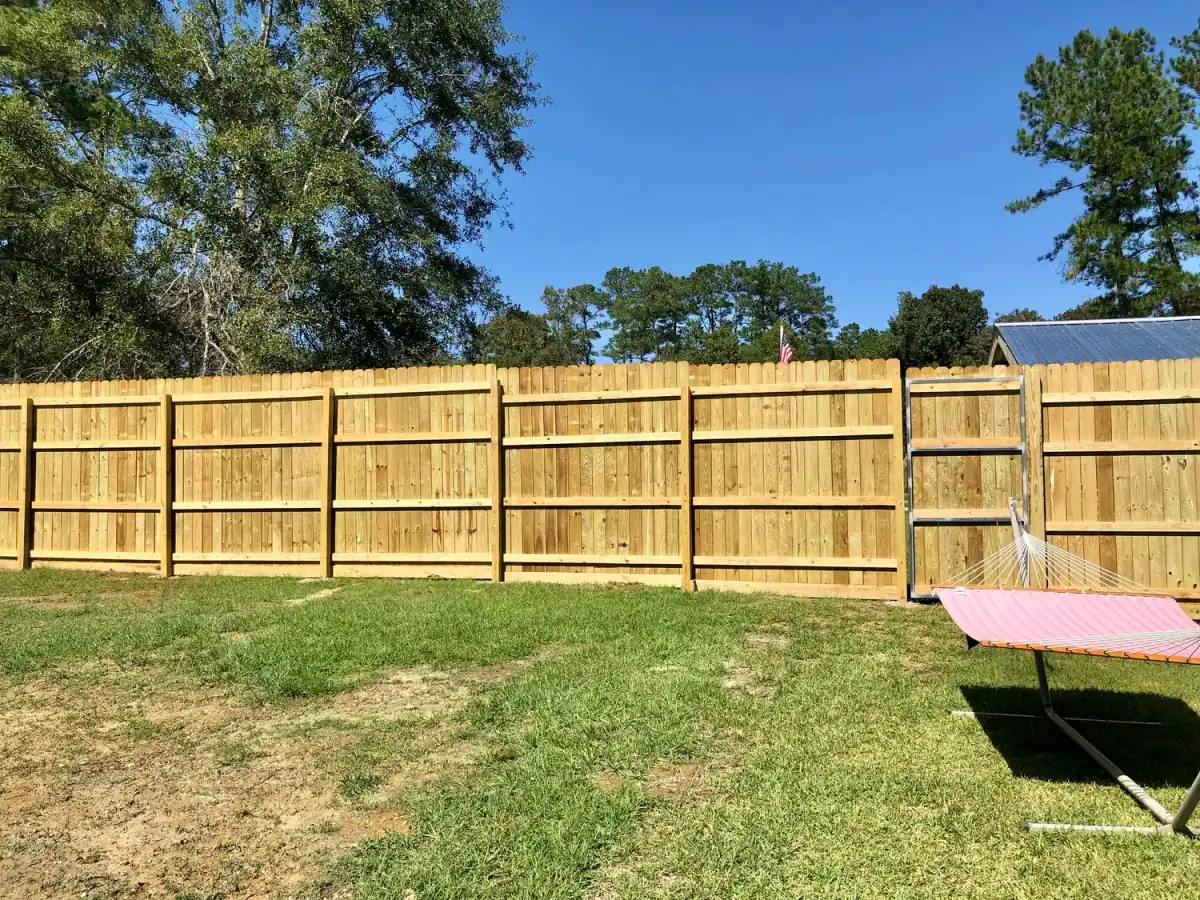 Board-on-board privacy fence with a cap rail