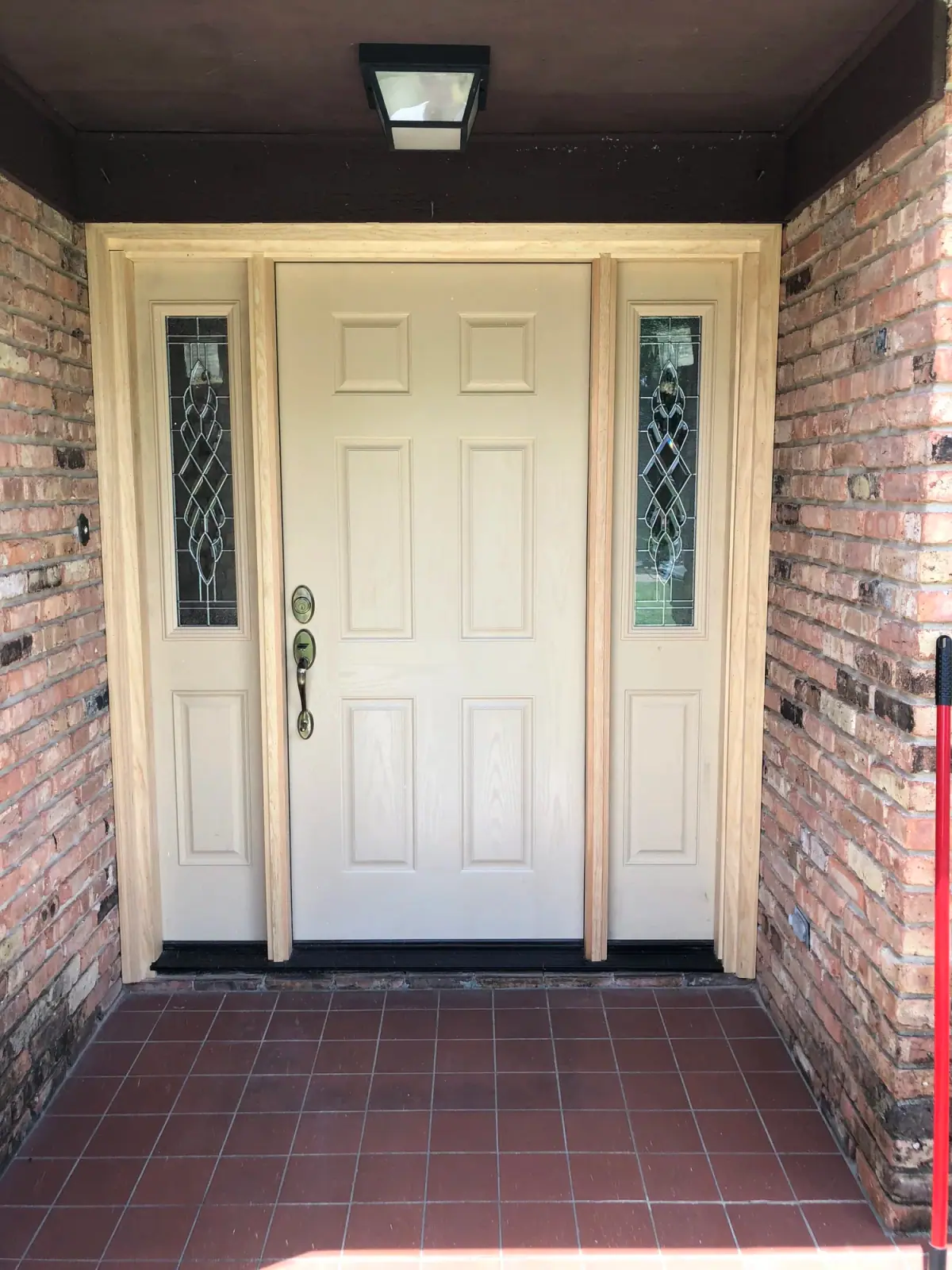 New front door with leaded-glass sidelights in a brick entry