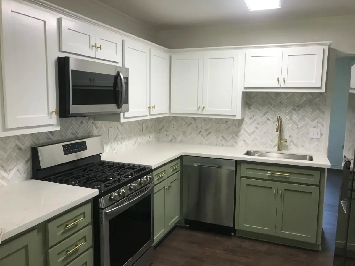 Kitchen with sage-green lower cabinets, white uppers and a gas range