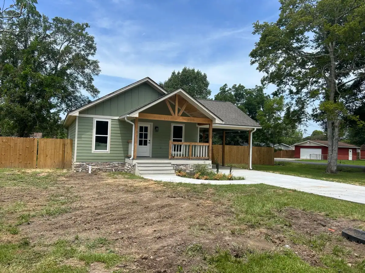 New-construction house with green board-and-batten siding and a covered porch