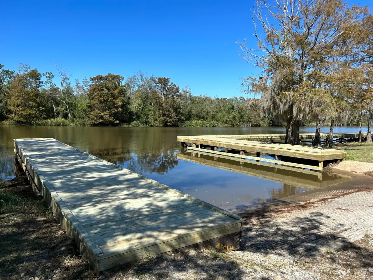Long pier over open bayou water on a clear day